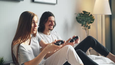 couple gaming on a bed