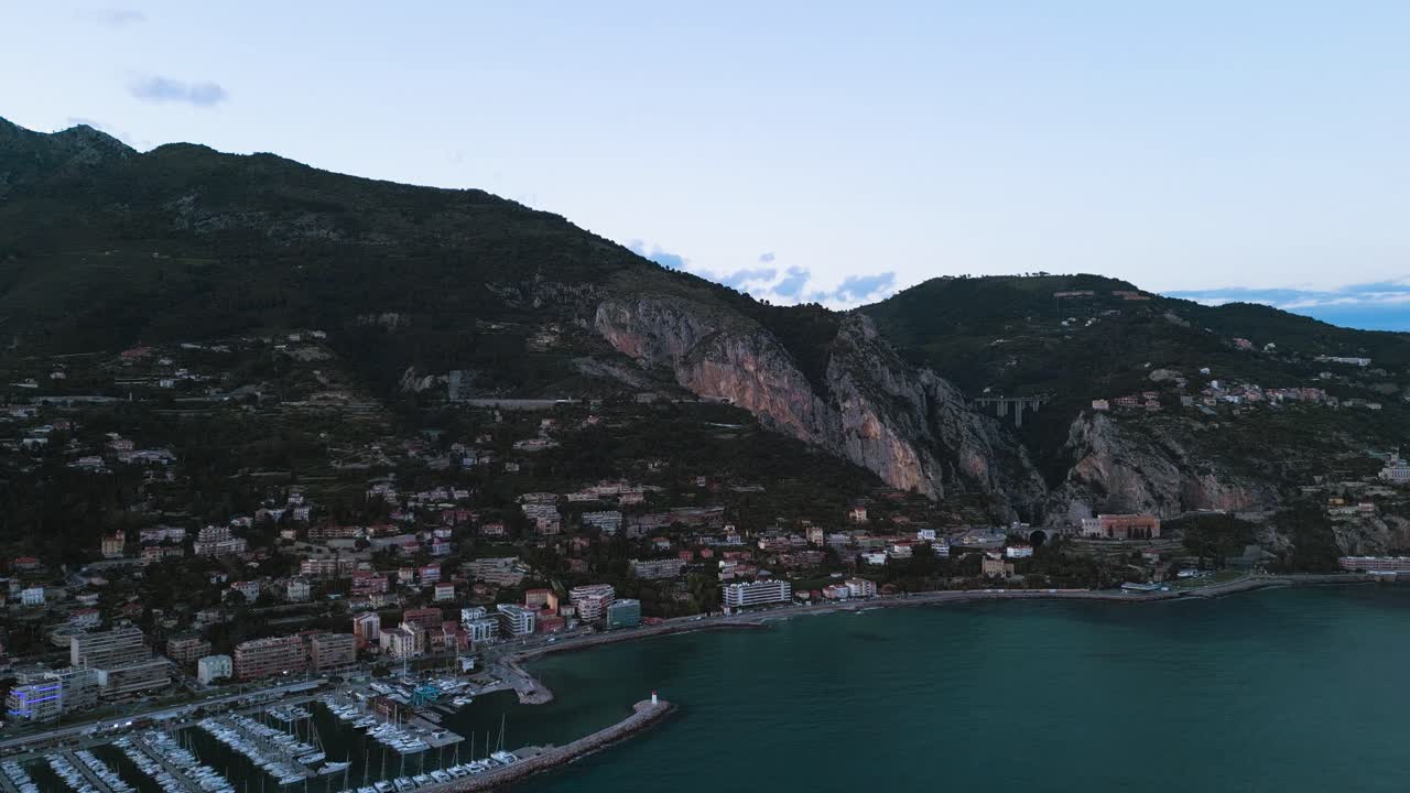 menton en la riviera francesa, destacando su belleza costera y sus montañas enclavadas al anochecer, vista aérea