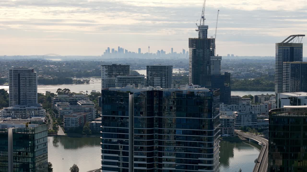 도시 진화: 먼 도시 실루을 한눈에 볼 수 있는 강변을 장식하는 현대적인 마천루