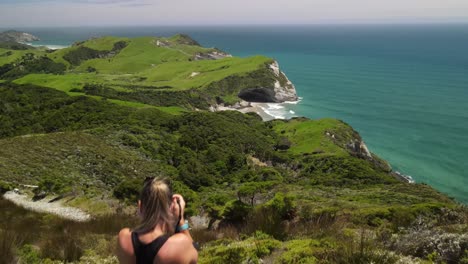 photographer on cliff top, amazing scenery of cape farewell coastal landscape, new zealand