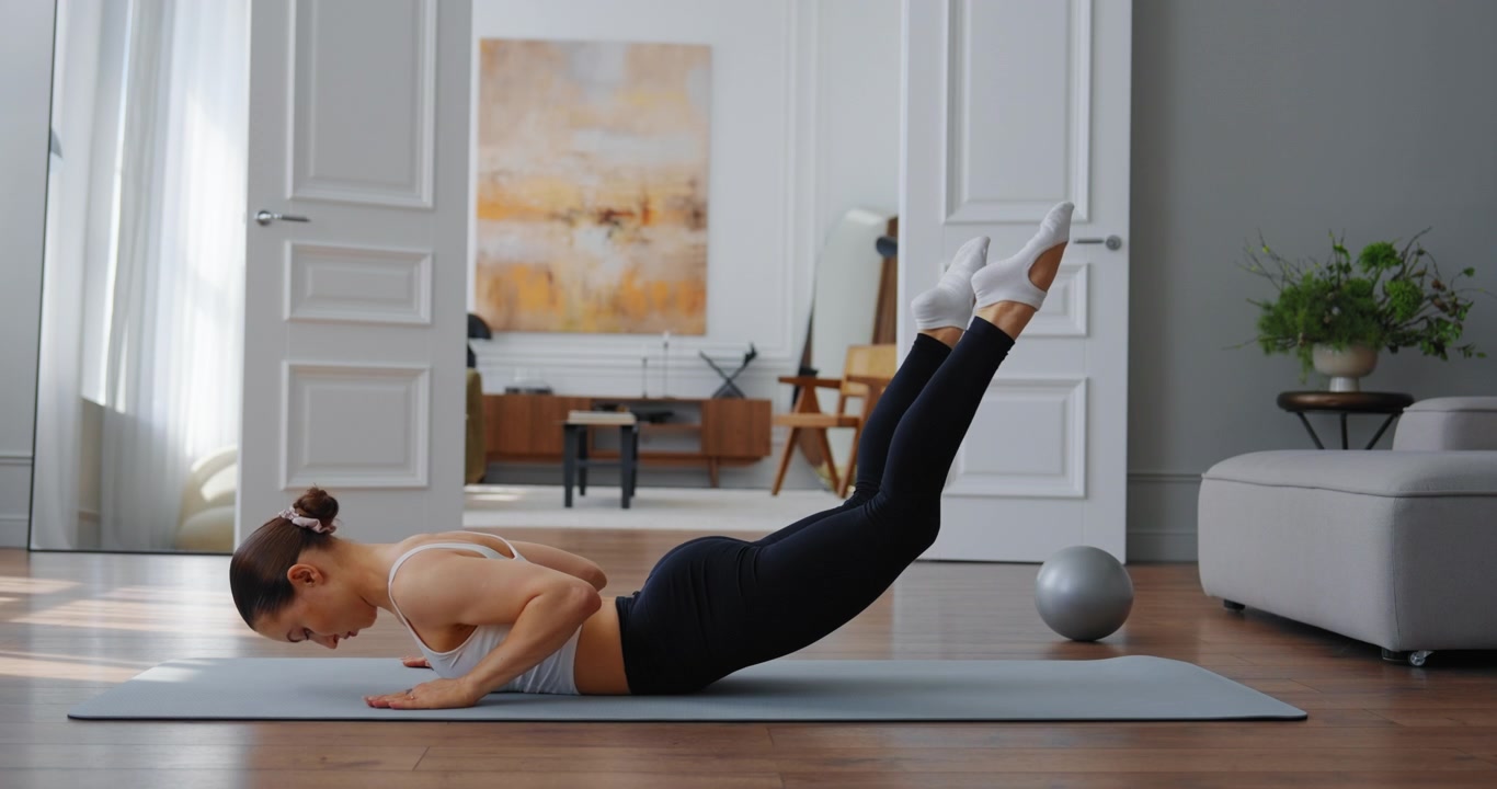 Fit Woman Doing Pilates and Yoga Exercises on Mat at Home