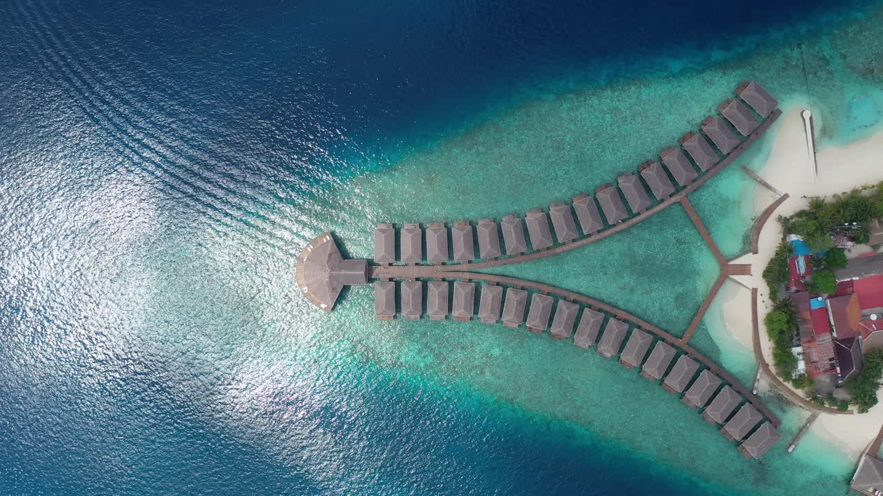 Vista aerea dall'alto di esclusivi bungalow sull'acqua in un resort alle Maldive