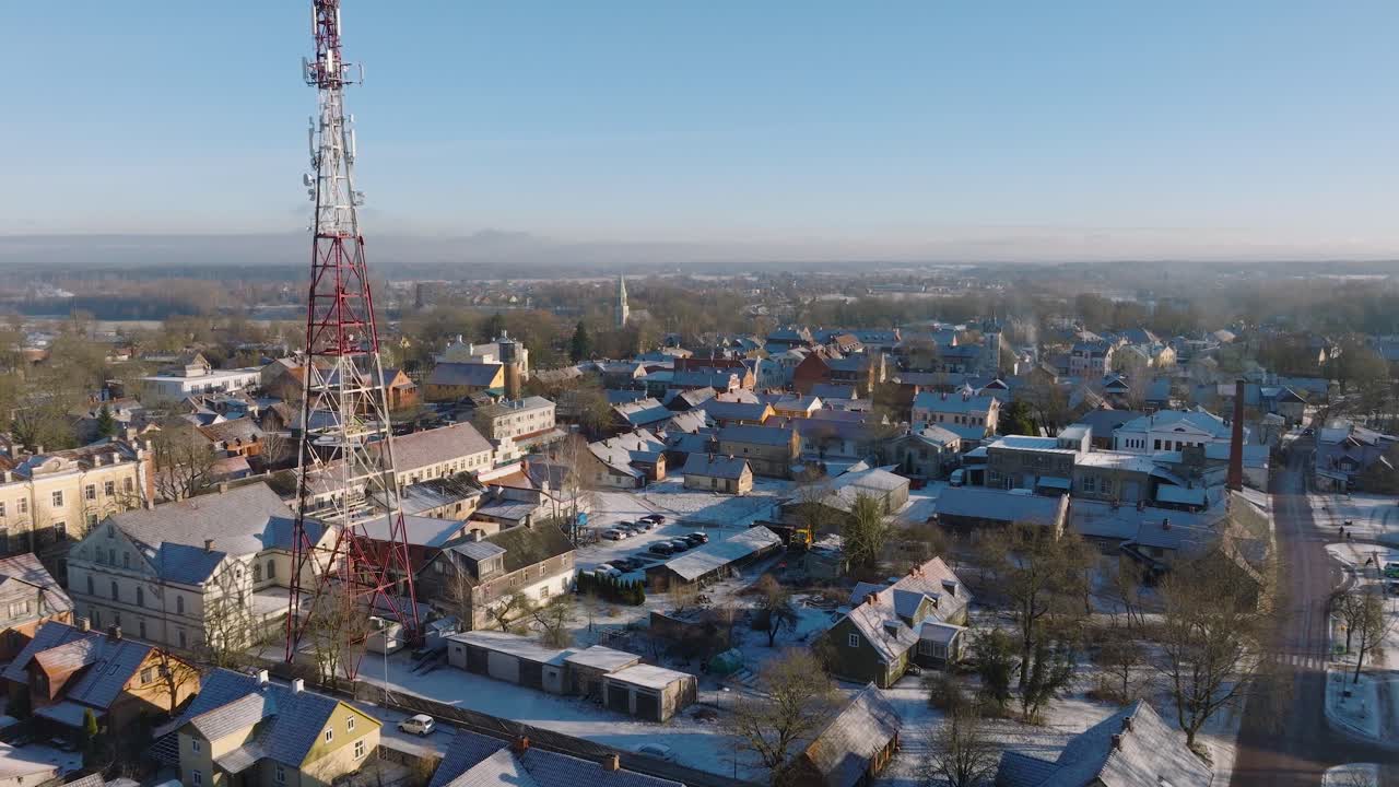 vista aérea del casco antiguo de kuldiga, casas con tejas rojas, torre de telecomunicaciones, día soleado de invierno, destino de viaje, amplia toma de dron moviéndose hacia adelante