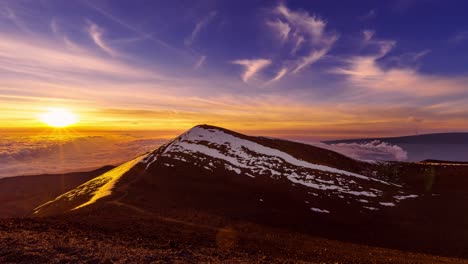 a beautiful scene of the sun rising with mauna loa eruption off in the distance