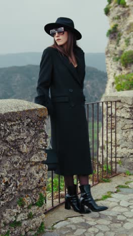 woman in total black with sunglasses admiring the nature surrounding her