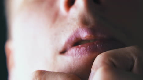 confused guy holds index fingers on chin under lip closeup