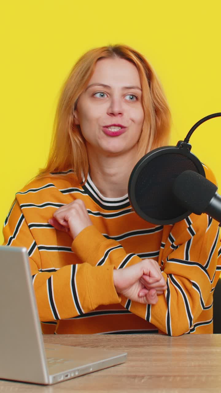 Woman blogger influencer recording podcast giving workshop webinar speaking in microphone and laptop