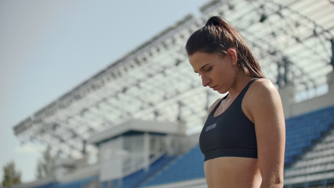 Slow motion: Athlete woman waiting in the starting block on running track