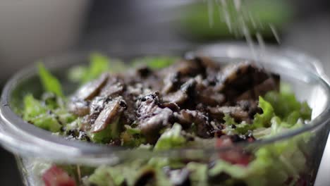 agregando queso parmesano en una ensalada de lechuga con champiñones