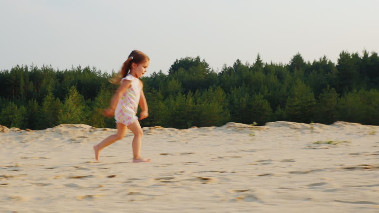 feliz niña alegre corre sobre la arena en un bosque infancia feliz prores hq 422 video de 10 bits