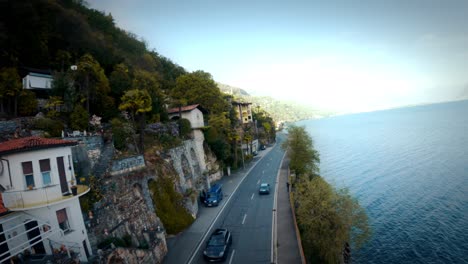 fpv drone shot over the water along the swiss and italian coastline, flying around boats, alongside cars, over trees, over water 6