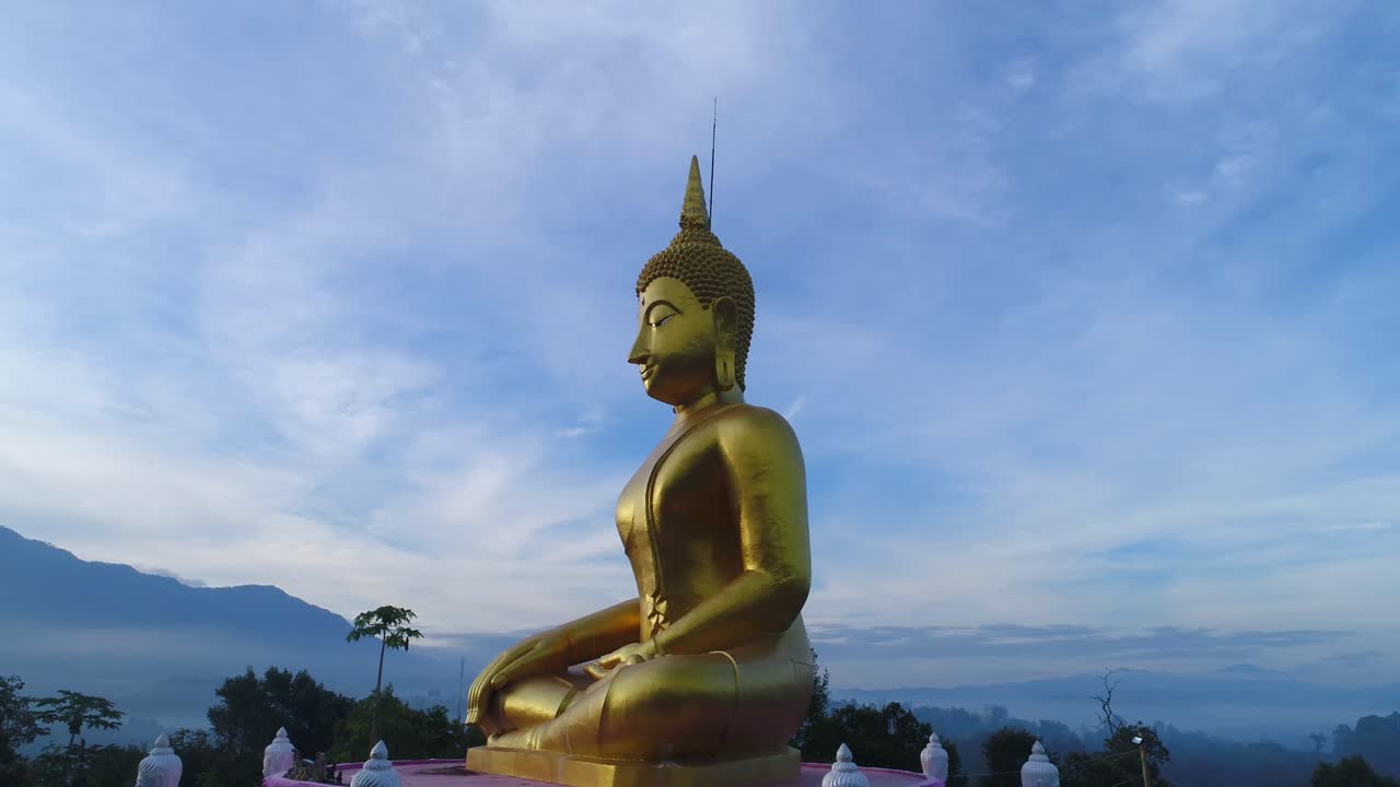 enorme grúa budda de oro disparó una estatua de avión no tripulado aérea que se eleva en las montañas de laos tailandia cinematográfica