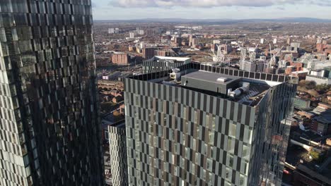 4k 60fps aerial drone flight overlooking the rooftop of south tower on deansgate in manchester city centre with the hilton hotel and gmex building in the background