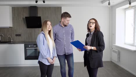 a young married couple communicates with a real estate agent about the possibility of buying an apartment, a man and a woman are in the kitchen