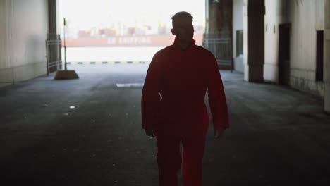 young worker in orange uniform walking through the harbour storage by the sea during his break. leisure time