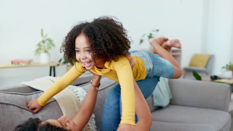 Mother,-child-and-lifting-in-air-on-sofa-in-home