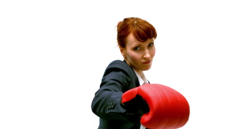 young businesswoman punching with boxing gloves