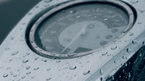 close view black motorbike speedometer under wet glass