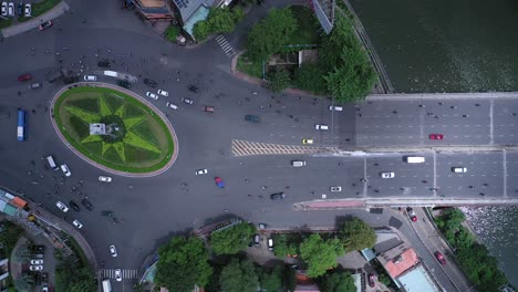 Traffic-roundabout-and-bridge-over-canal-from-top-down-aerial-view-with-star-shaped-garden-in-its-center-during-the-day