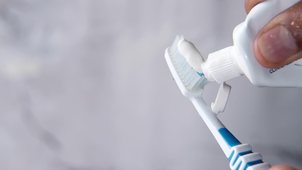 la aplicación de pasta de dientes a un cepillo de dientes