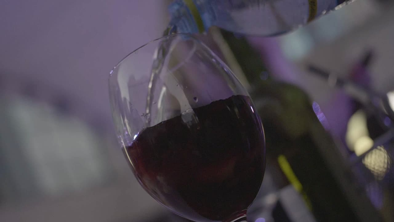 Pouring water into a glass of red wine