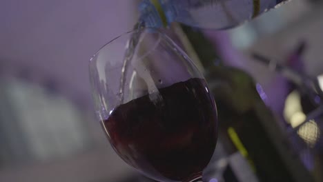 vertiendo agua en un vaso de vino rojo