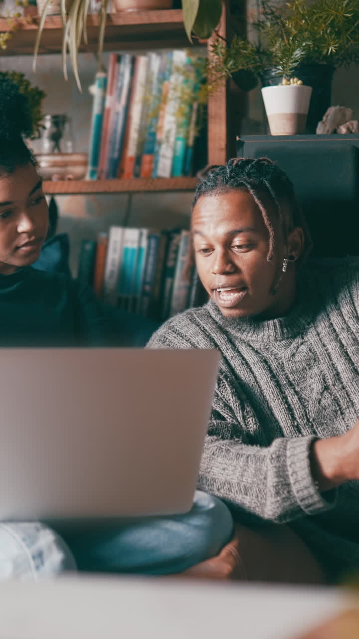 Young Couple Discussing Content on Laptop at Home