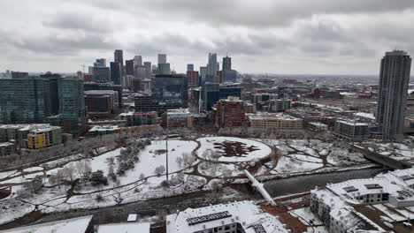 zimowa antena śnieżnego parku commons z panoramą denver na tle nastrojowego szarego nieba