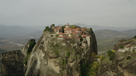 aerial view away from a monastery, in cloudy meteora, greece - pull back, drone shot