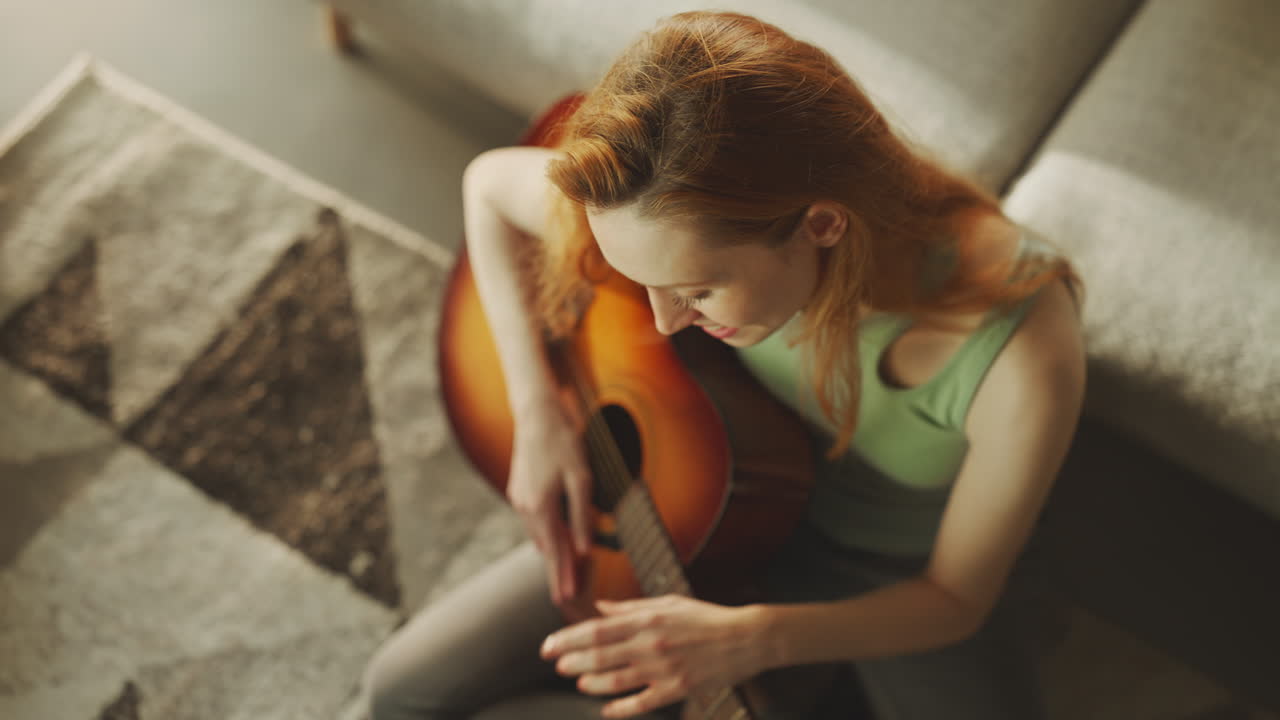 una mujer aprende a tocar la guitarra.