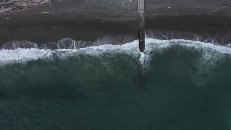 Langsames-Luftzoom-Aus-Den-Wellen,-Die-Am-Strand-Krachen