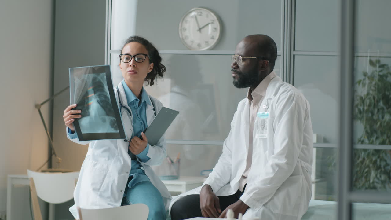 médicos multiétnicos discutindo radiografia de tórax no trabalho na clínica