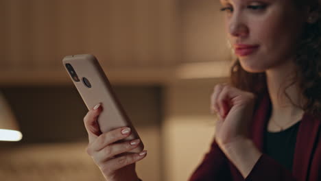 manager reading message mobile phone in night office close up. smiling woman