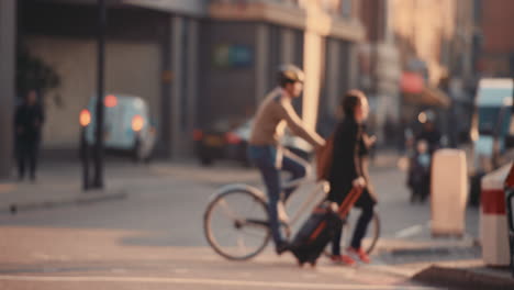 anonymous crowd of people walking cycling bicycles commuters london city street slow motion