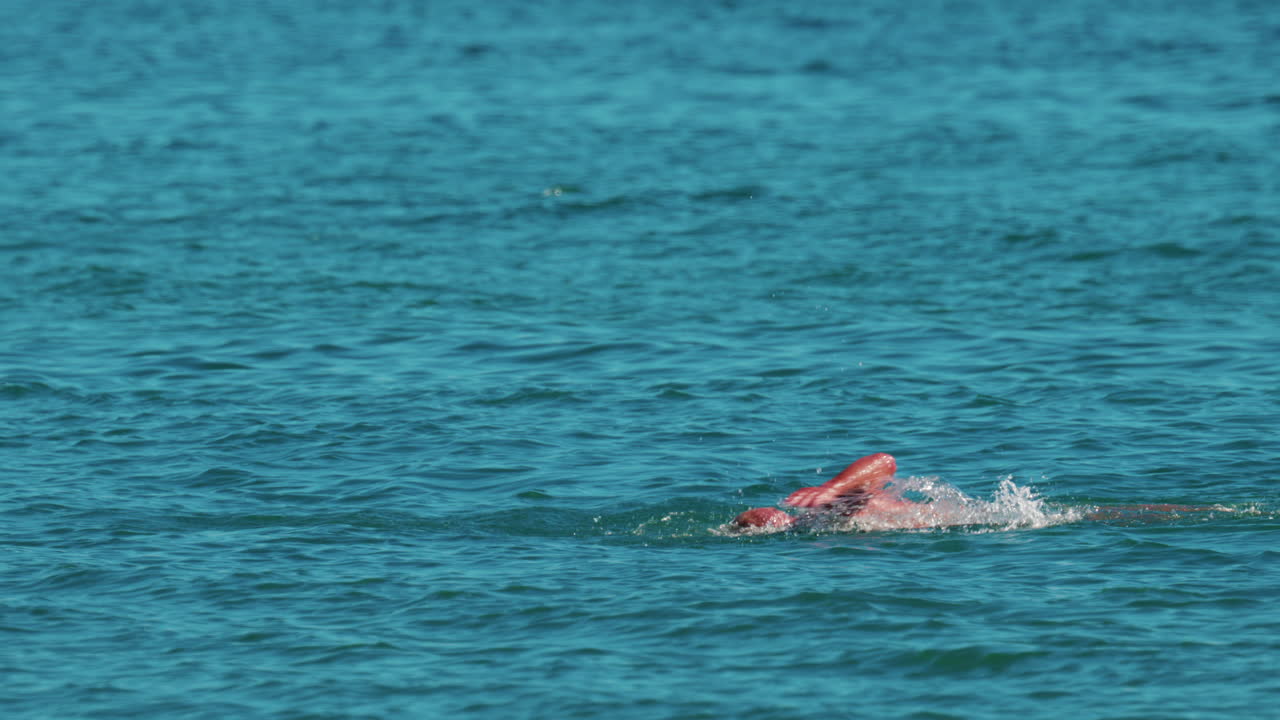 Man swimming freestyle in the calm turquoise water off the coast of Cannes, France