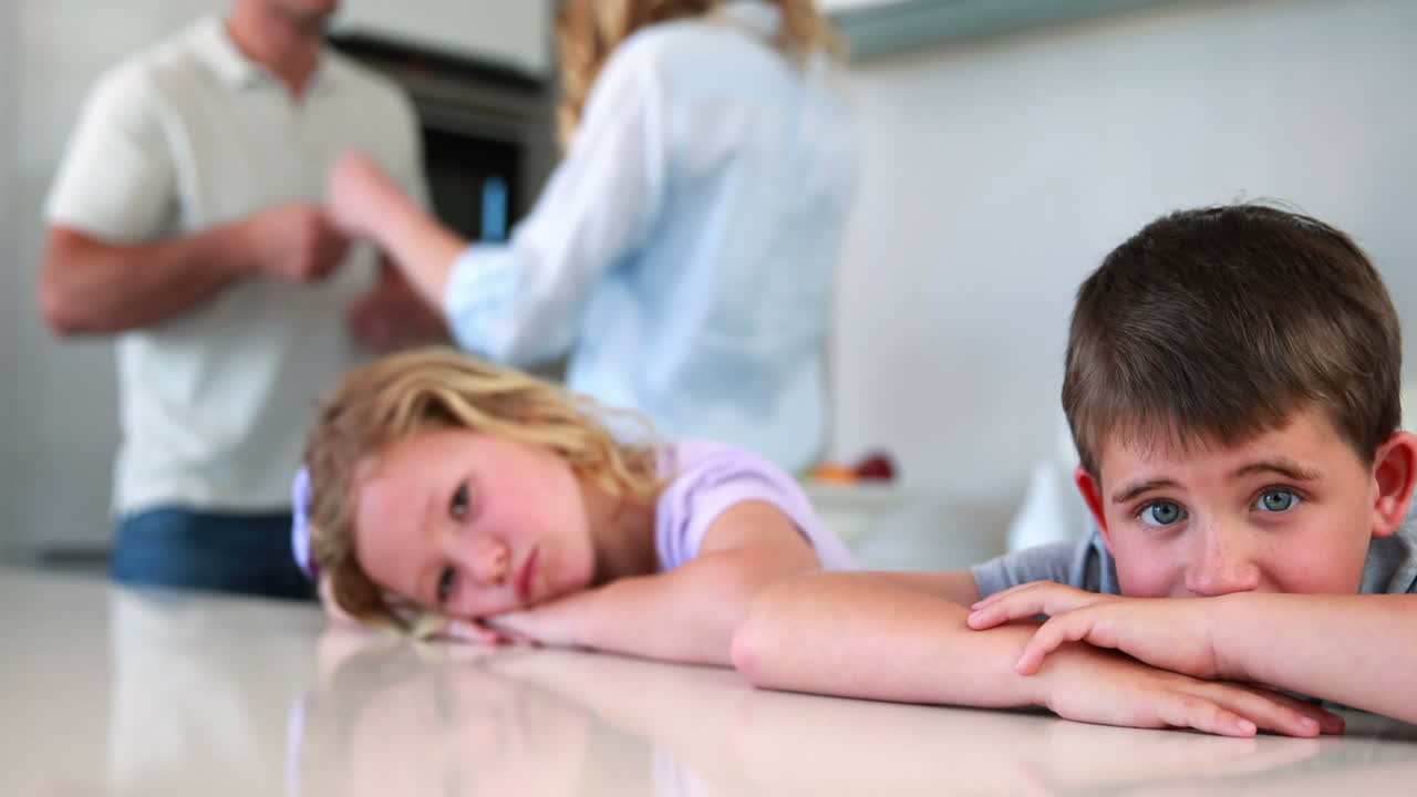 어린 형제 자매들은 부모의 싸움의 소음을 막고 있습니다.