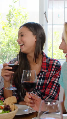 amigos felices comiendo un almuerzo saludable con vino