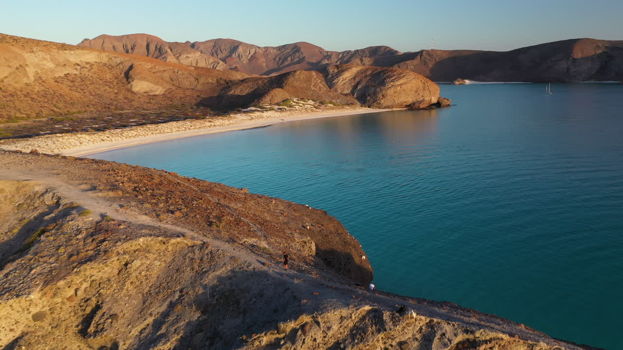 Ampia inquadratura di un uomo che cammina su una cresta a Balandra Beach, ripresa con drone