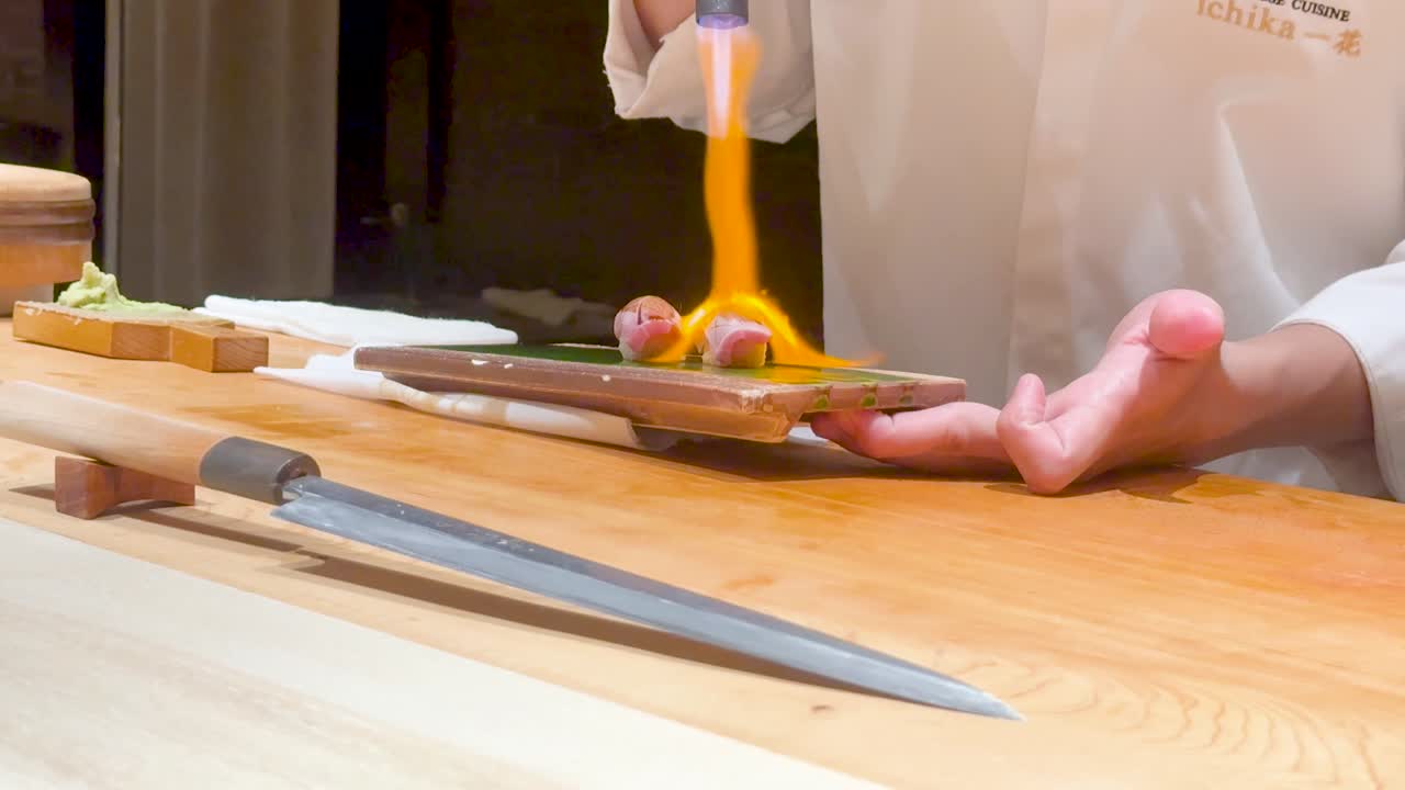 el chef hábilmente quema el sushi para mejorar el sabor