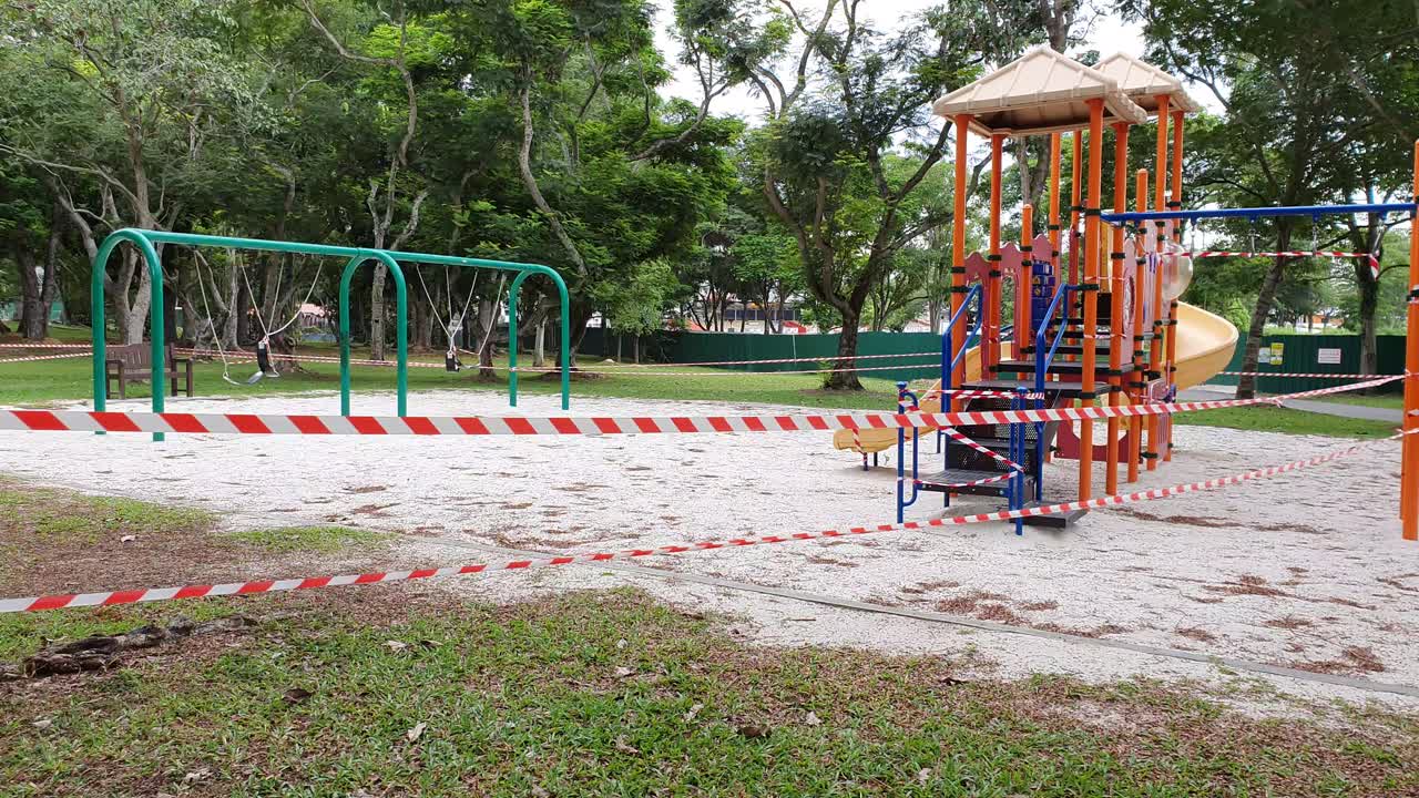 Children's playground with barrier tape and warning signs during Covid-19 lockdown in a public park in Singapore, Asia