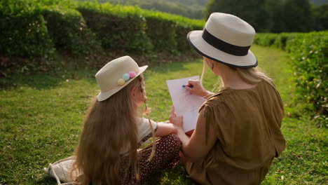 mother and daughter drawing in a tea plantation