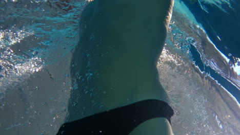 underwater view of man swimming and diving