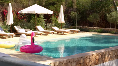 Outdoor-swimming-pool-and-garden-with-sun-loungers,-shot-on-R3D