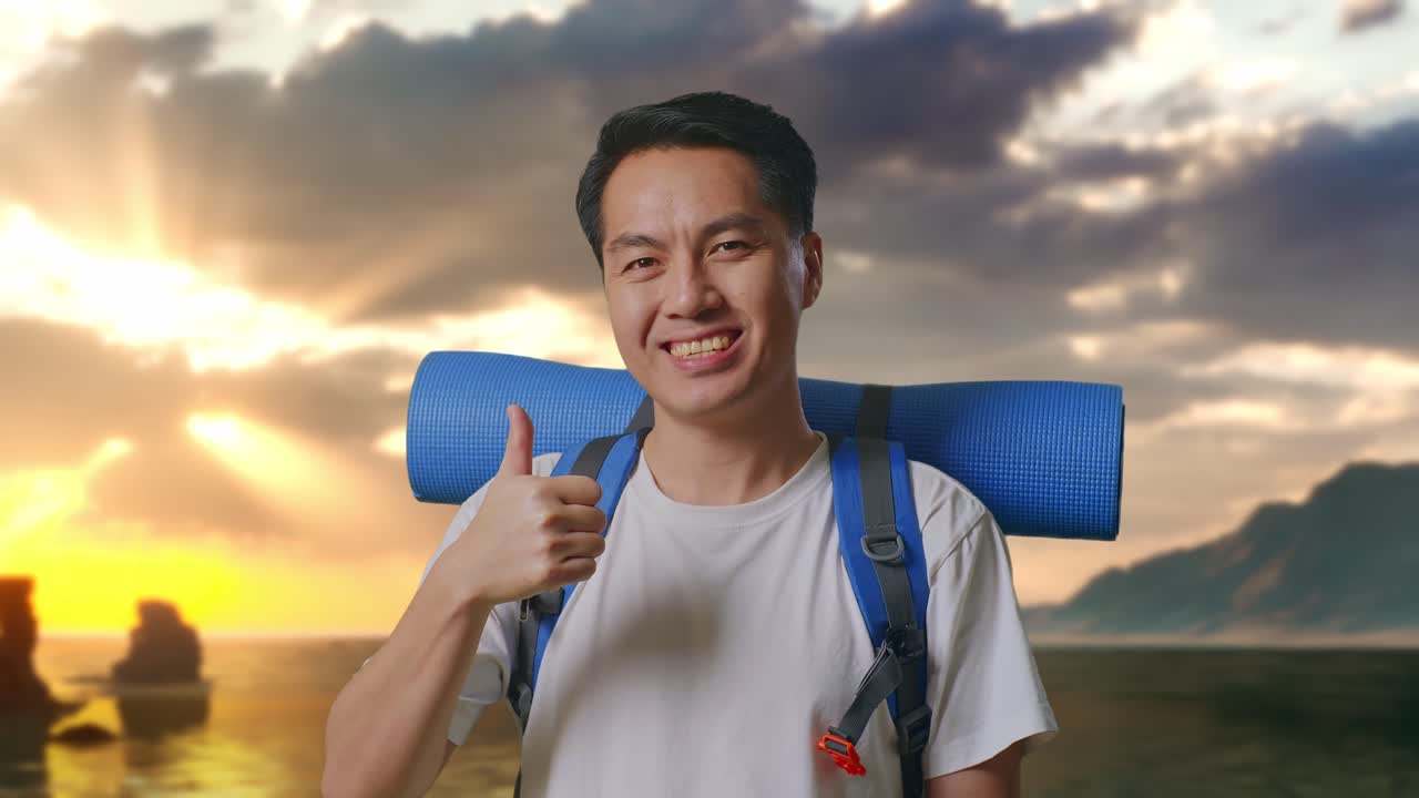 Close Up Pendaki Pria Asia Dengan Ransel Gunung Tersenyum Dan Menunjukkan Jempol Ke Atas Ke Kamera di Pantai