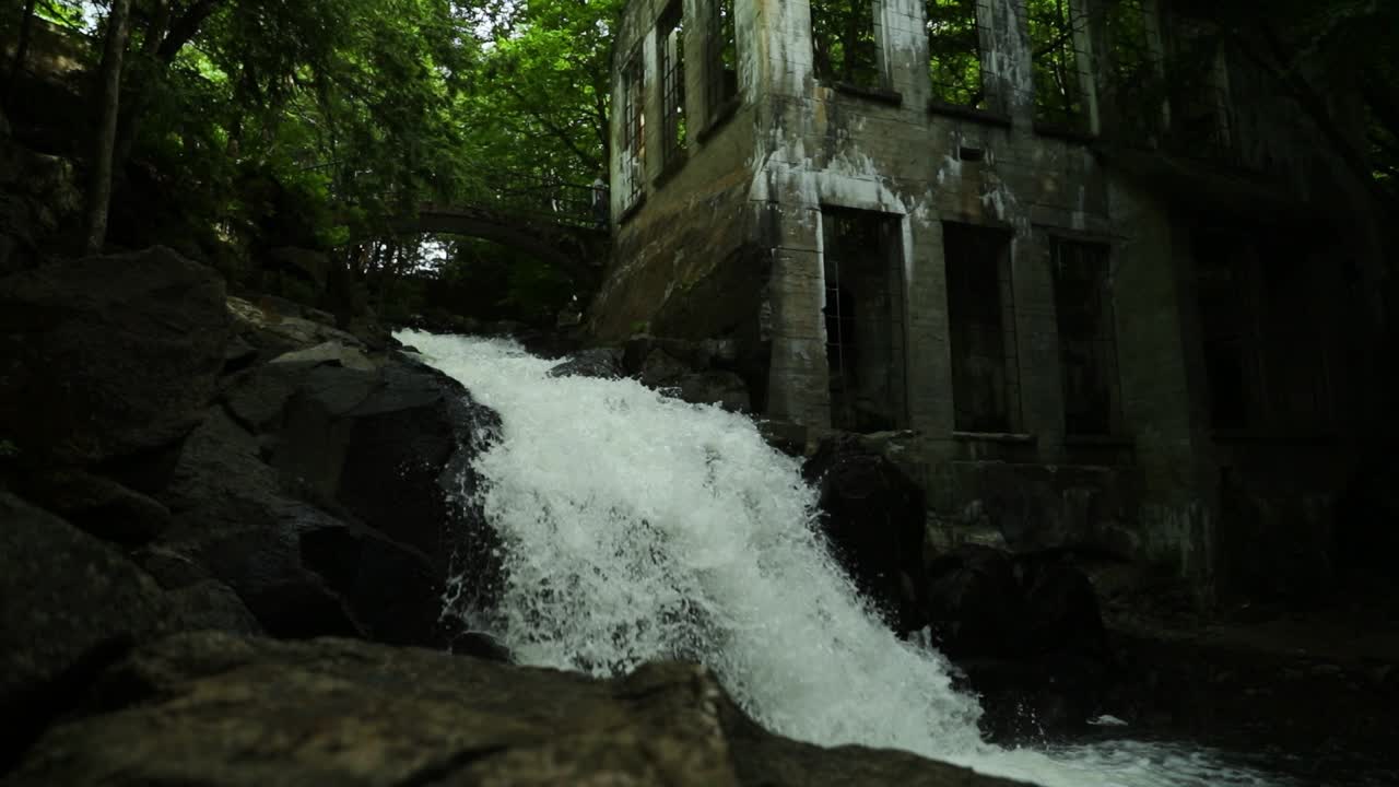 cascada cayendo por el costado de un molino abandonado en el parque gatineau, quebec
