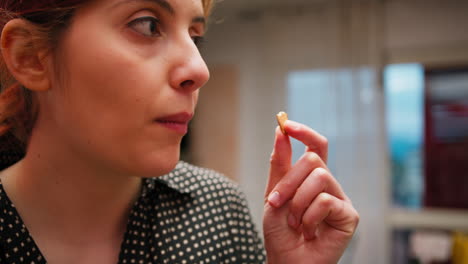 woman eats dry fruit almond healthy in the kitchen