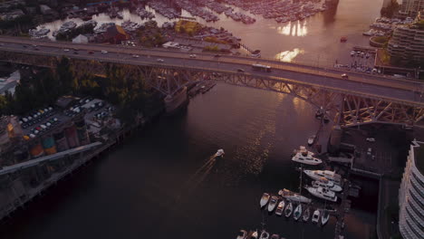 aerial view of cityscape at sunset with bridge and boats