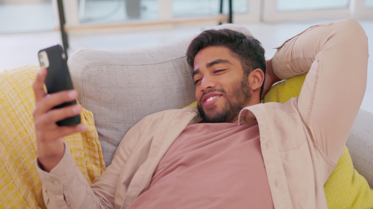 riendo, hombre y teléfono inteligente en el sofá en el salón