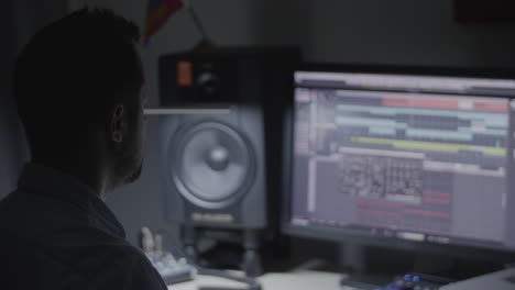 productor, ingeniero de sonido, músico revisando la mezcla de sonido en su estudio y reaccionando al ritmo de la música