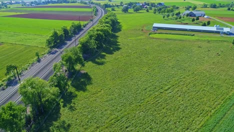 An-Aerial-View-of-Electrified-Rail-Road-Tracks-in-the-Middle-of-Patch-Worked-Farmlands-on-a-Sunny-Day